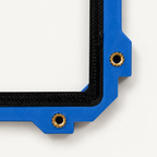 Brass heat-set inserts in the corner of the Slabster EXO frame, next to the black TPU cradle, close-up