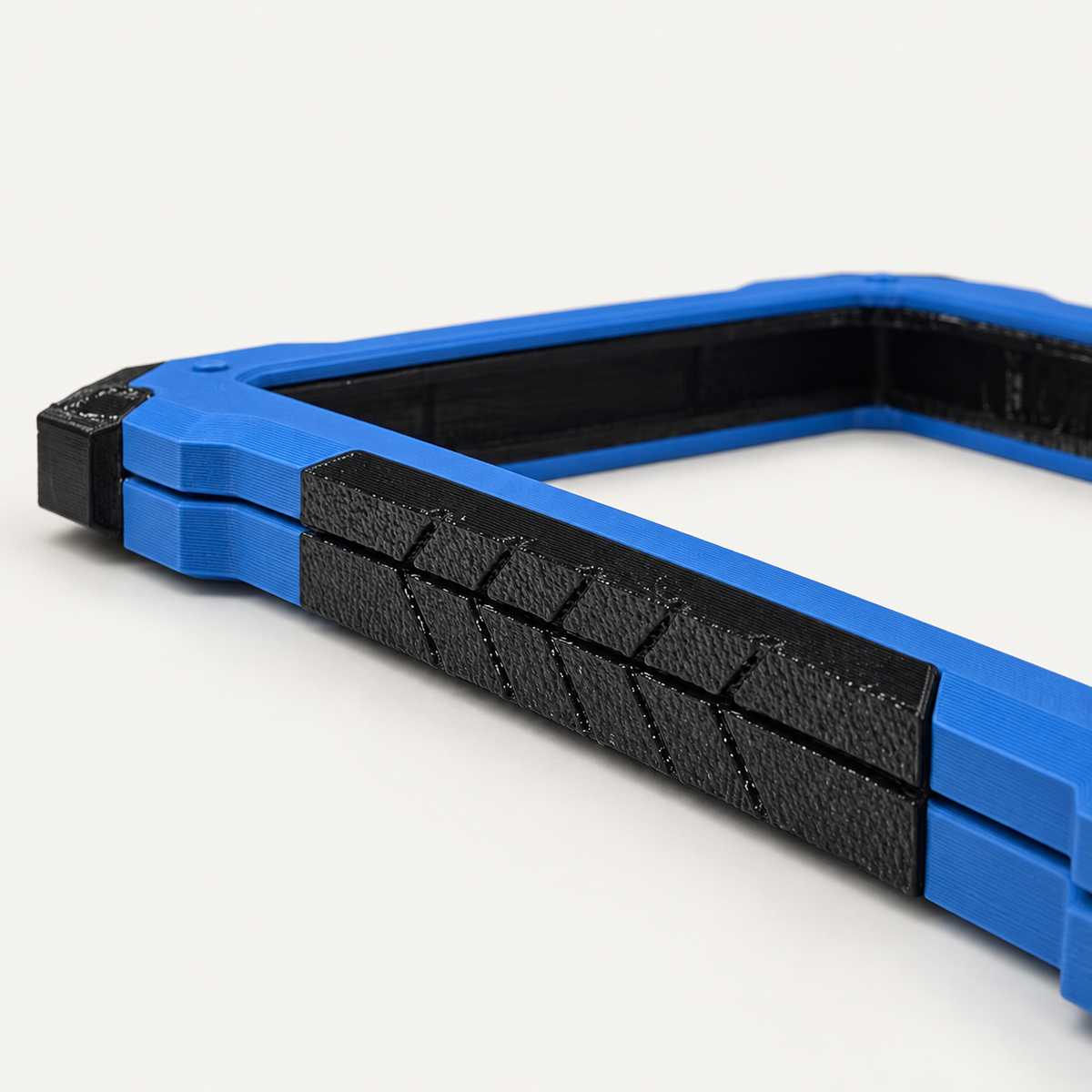 Textured black TPU side strip on two stacked Marine Blue Slabster EXOs, close-up