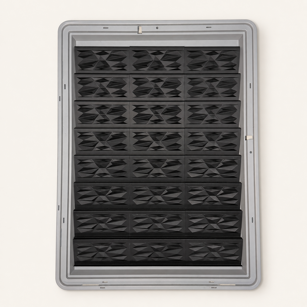 24 black faceted risers with triangular panels inside a gray Zion display case