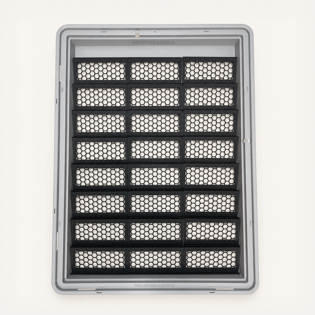 Top-down view of 24 black honeycomb risers in three columns inside a gray Zion display case